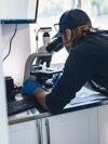 Farm employee with microscope